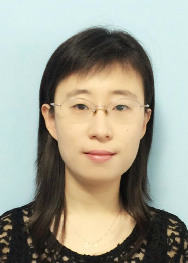 Porträt einer Frau mit Brille und dunklen Haaren.