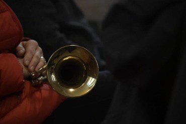 Nahaufnahme einer Hand, die eine Trompete hält.